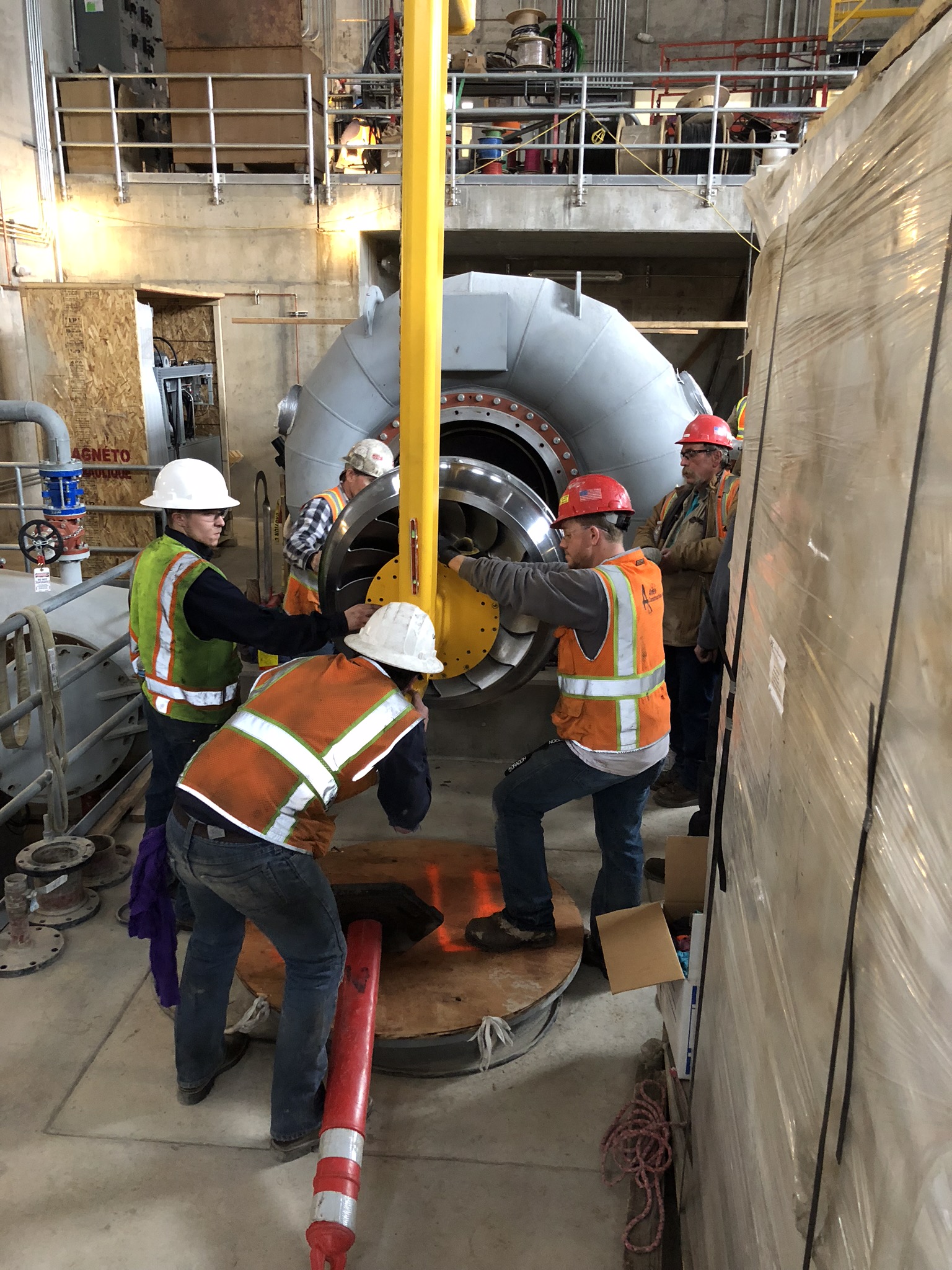 Employees and construction workers placing the turbine in the new powerhouse