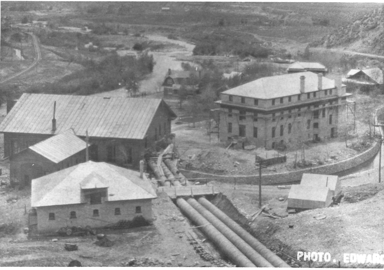 Black and white photo of penstock and old power house