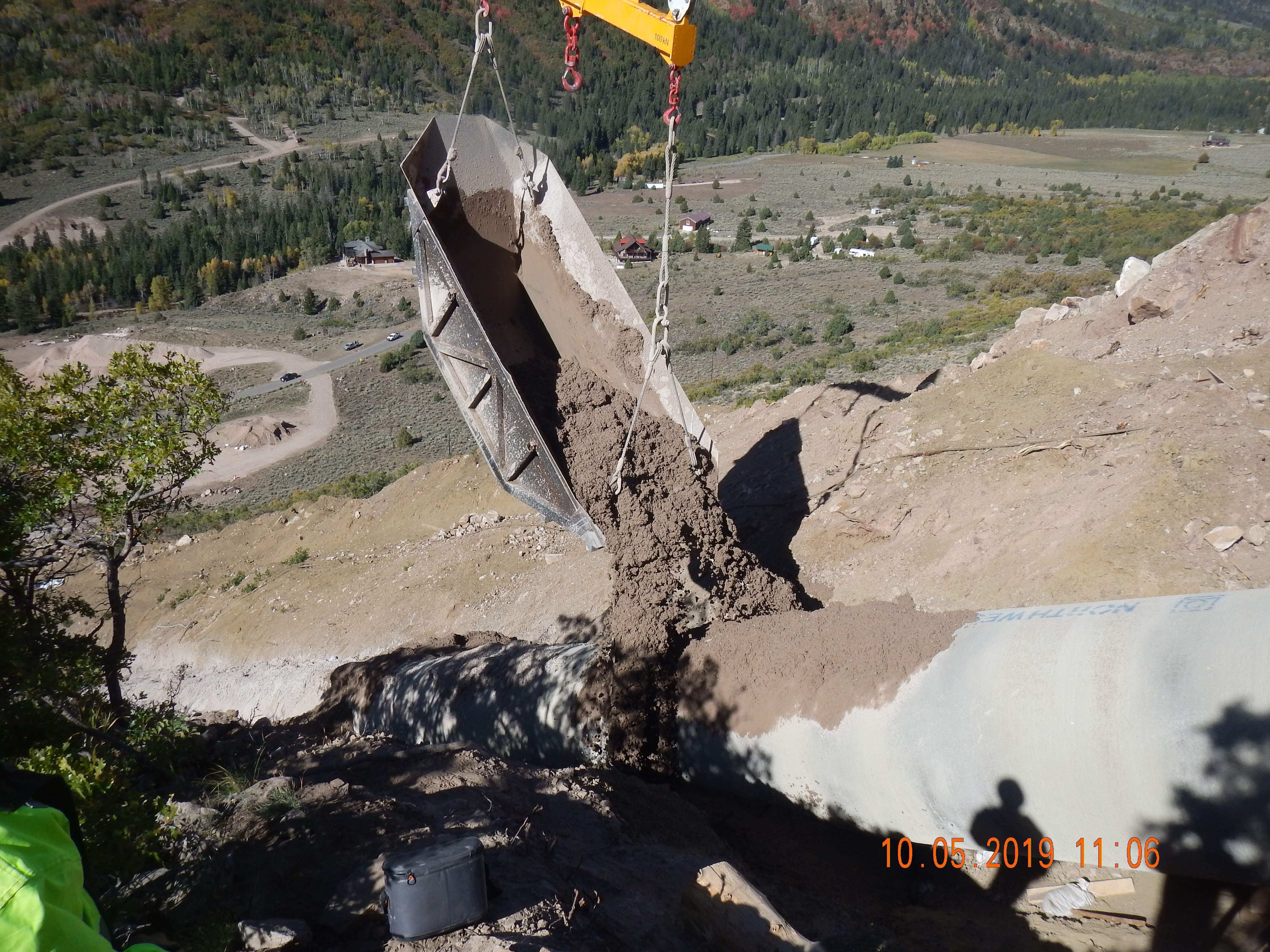 Dirt being dumped on piping from crane